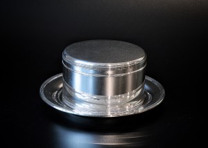 Zilveren koektrommel op onderschotel, rond model.